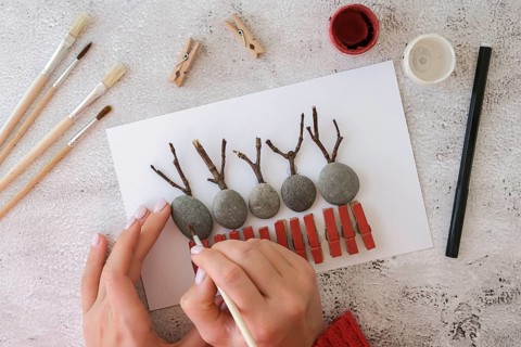 Diy Merry Christmas deer on greeting card postcard made of pebbles, sea stones, clothespins and