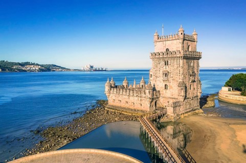 Drone shot of Belem tower landmark, Lisbon, Portugal at blue summer day sky. Medieval fortification