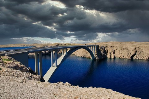Impressive bridge spans a river under a dramatic, cloudy sky, Pag Bridge, Pag, Dalmatia, Croatia,