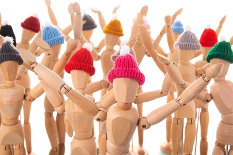 Many wooden mannequins with winter hat isolated over white