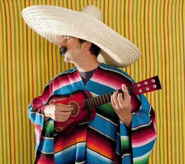 Mexican man serape poncho sombrero playing guitar typical Mexico