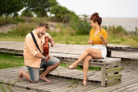 Woman dancing while sitting while her boyfriend plays guitar and sings