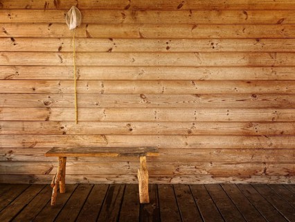 Butterfly net and bench against wooden wall