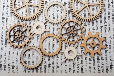 Wooden cogwheels on a page of a book. Industry concept information