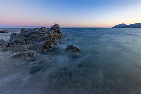 Rocks in the sea on the beach of Torre di Bari at sunset, long exposure, Torre di Bari, Bari Sardo,