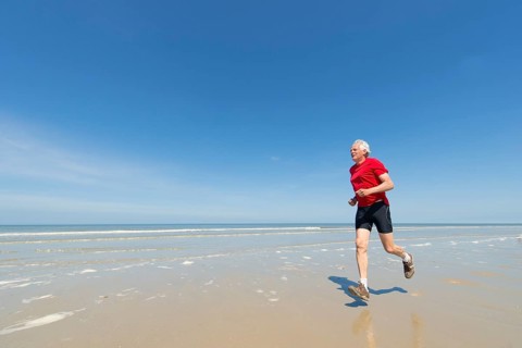 Elder man running at the beach