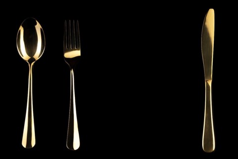 Golden knife and spoon on a black background. Cutlery