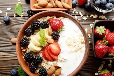 Flat lay top view at Fruit healthy muesli with banana strawberry almonds and blackberry with yogurt