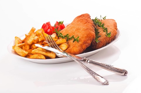 Pork schnitzel with chips on a porcelain plate