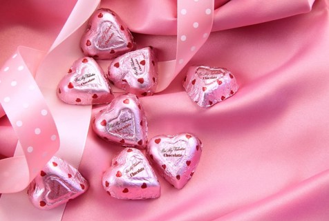 Valentine's chocolate hearts on pink satin with ribbon