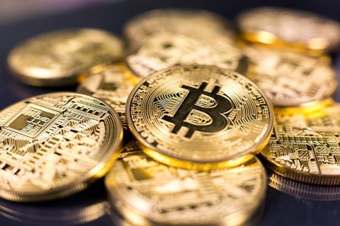 Stack of bitcoins lying on shiny dark surface