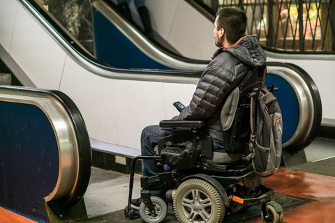 Rear View Of A Disabled Man On Wheelchair In Front Of Staircase