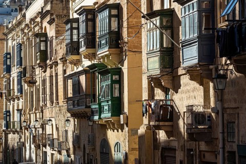 Valletta, Malta, 01 07 2022: Historical houses with wooden bow windows and terraces in a narrow