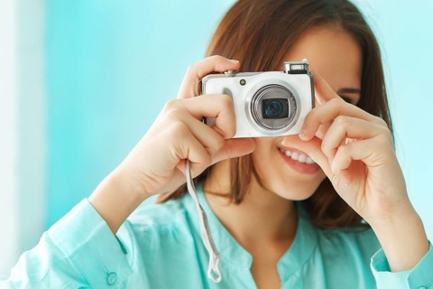 Close up portrait of a beautiful cute teen girl with digital photo camera