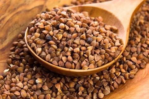 Buckwheat seeds on wooden spoon in closeup, lodz, poland