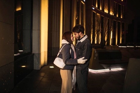 A couple shares an intimate moment, forehead to forehead, at night