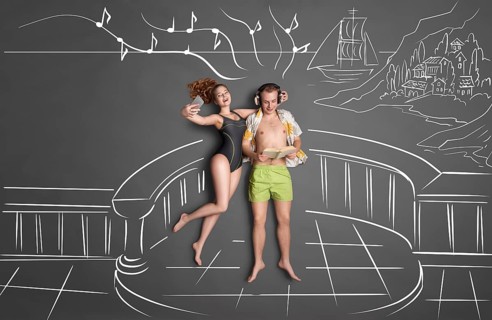 Love story concept of a romantic couple on the shore against chalk drawings background, view from
