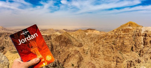 Lonely Planet travel guide against dramatic Jordan mountains and sky to promote travel and tourism
