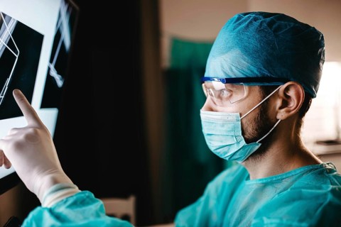 Surgeon pointing at detailed x-ray results for evaluation