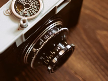 Close up photo of old vintage camera lens over wooden table. selective focus