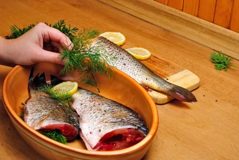 Fish carcass with spices on wooden hardboard, prepared for cooking