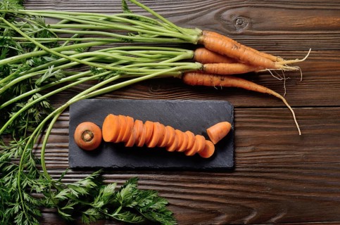Top view at fresh organic Carrots on kitchen wooden table