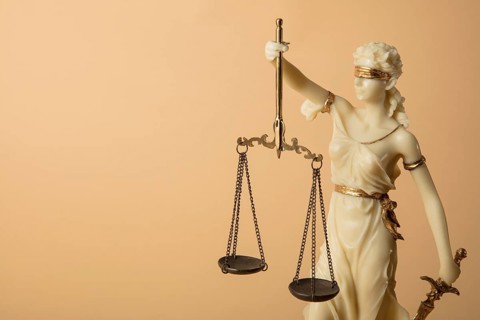 Justizia Figur auf beige Hintergrund
