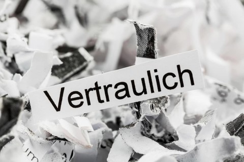 Paper shreds with the keyword Confidential, symbolic photo for data destruction and confidentiality