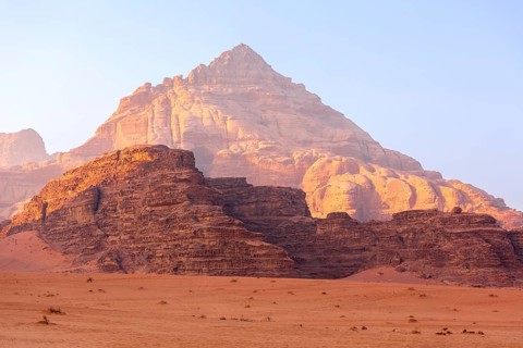 Wadi Rum, Jordan. The orange sand desert landscape and Jabal Al Qattar mountains at dawn, sunset