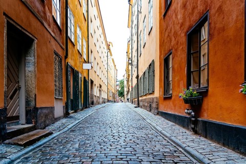 Beautiful old cobblestoned street amidst old colorful houses in Gamla Stan Quarter in Stockholm