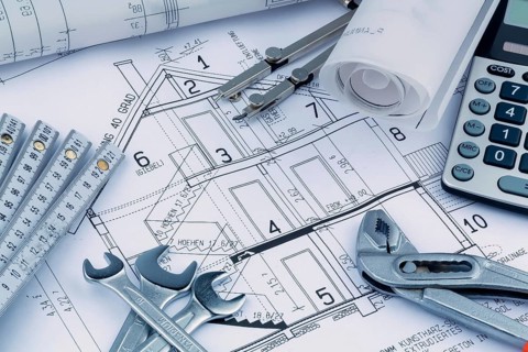 An architect's construction plan with a calculator. Symbolic photo for financing and planning a new