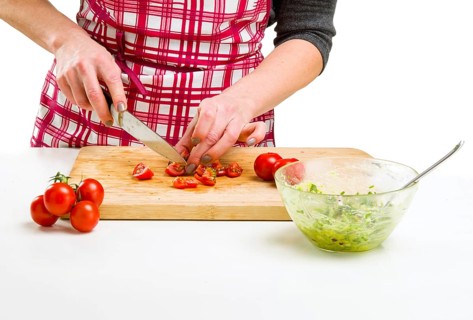 Young Woman Cooking in the kitchen. Healthy Food - Vegetable Salad