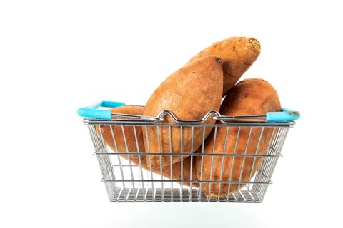 Shopping basket with sweet potatoes isolated over white background