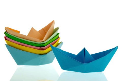 Colorful folded paper boats isolated over white background