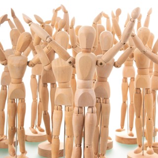 Many wooden mannequins isolated over white