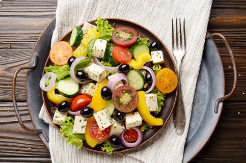 Top view at Mediterranean diet dish greek salad on vintage metal tray