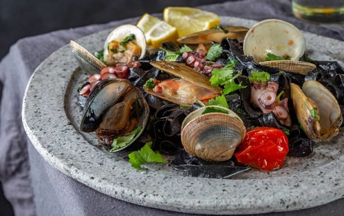 Food, Seafood black fettuccine fehttuchini. Black pasta with squids, octopus clams, mussels on