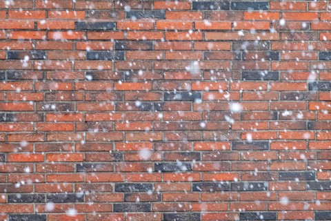 Snowflakes in front of a brick wall