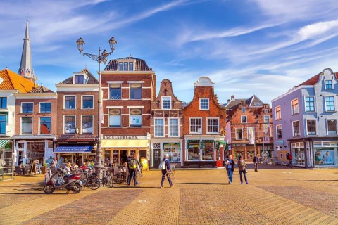 Delft, Netherlands, April 8, 2016: Colorful street view with traditional dutch houses on the
