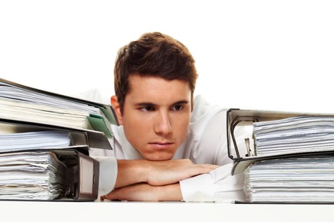 A manager under stress with piles of files. Bureaucracy in Administration Austria