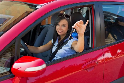 Young woman with new car and car keys