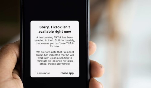 An iPhone screen with the TikTok homepage showing Sorry, TikTok isn't available right now