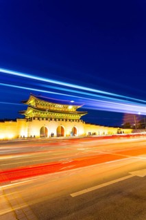 Colorful streaks of light from car lights on moving traffic in front of historic Gyeongbokgung