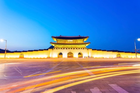 Long exposure car lights curving in front of Gwanghwamun main entrance gate to Gyeongbokgung Palace
