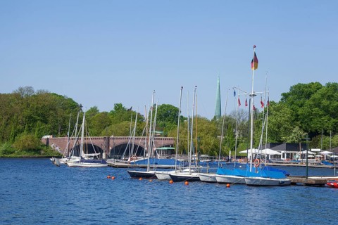 Krugkoppelbrücke with boat hire and Bobby Reich restaurant on the Outer Alster in spring,