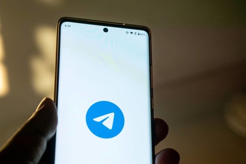 Smartphone on surface showing Telegram logo