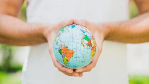 Close up man s hand holding small globe