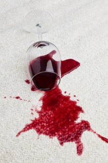 A toppled glass of red wine soils a carpet, A toppled glass of red wine with a dirty carpet.
