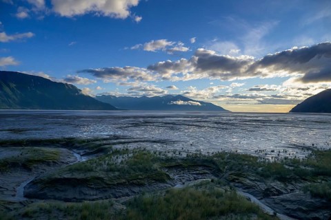 Vast coastal landscape at sunset with calm water under a cloudy sky, Turnagain Arm, Alaska, USA,