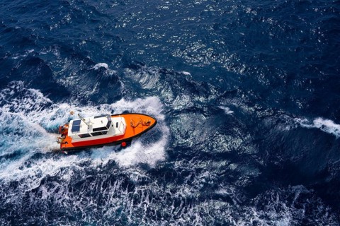 Pilots boat aerial view sailing in blue ocean sea with foam wake